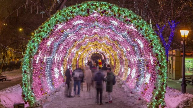 Timelapse of the decorated light tunnel on Tverskoy Boulevard during a winter holiday night in Moscow, with people walking inside