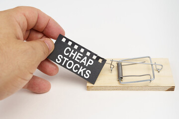 A man pulls the bait from a mousetrap. Bait, a sheet of black paper with the inscription - cheap...
