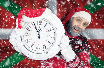Santa Claus holds a clock in his hands against the background of the flag of Basque lands
