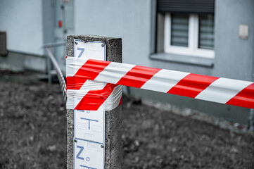 Red and White Lines of barrier tape. at street background. Red White warning tape pole fencing is...