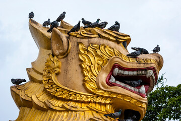 Gilded big dragon head with pigeons on top, Yangon, Myanmar, Asia