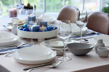 Festive table setting with burning candles and Christmas balls