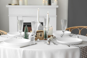 Festive table setting with burning candles and Christmas decor