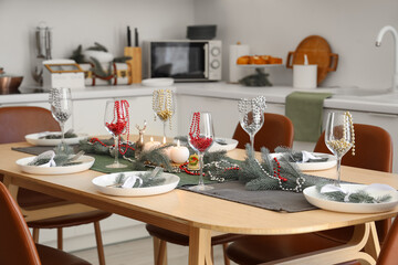 Beautiful table setting with Christmas decor and beads in interior of festive kitchen