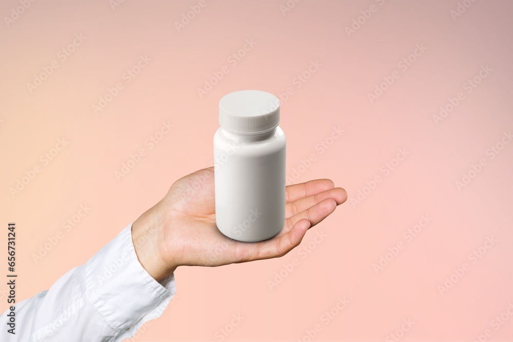 Poster Human hand holding white blank bottle. Packaging for supplements.