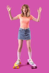Young woman with skateboard on purple background