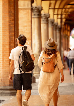 Tourist couple exploring Bolongo, Italy. They visit the porticos.