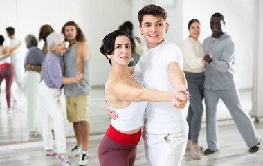 Photo sur Plexiglas École de danse Caucasian man and lady rehearsing latin paired dance moves