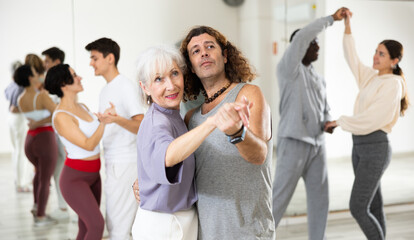 Caucasian man and mature woman rehearsing latin paired dance moves