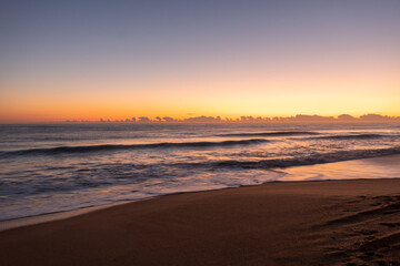 Fototapeta premium Waves crashing during sunrise on the beach