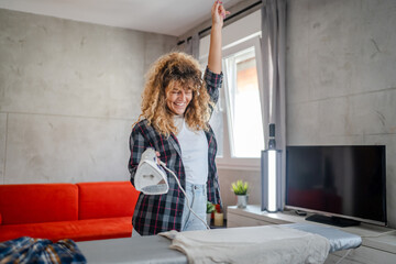 one woman ironing clothes at home hold iron household chores concept