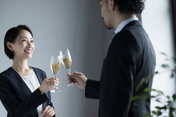 ワインで乾杯するスーツを着た男女