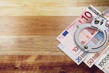 Police handcuffs and money bill pile