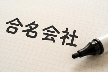 合名会社と書かれたノートとマーカー