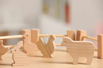 Fototapeta na wymiar Wooden animals and fence on table, closeup. Children's toys