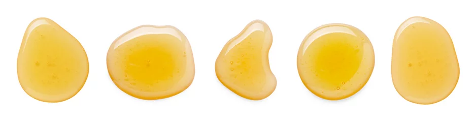 Fotobehang Drops of sweet golden honey isolated on white, set. Top view © New Africa