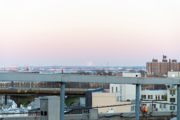 The Moon sets behind the elevated portion of the Brooklyn Queens Expressway BQE as seen from a...