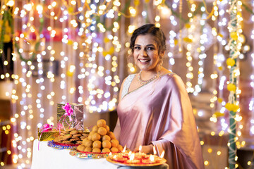 Portrait of beautiful woman dressed in sari looking at camera during diwali festival.