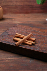 a cup of tea and cinnamon with a dark mode theme on a brown wood background