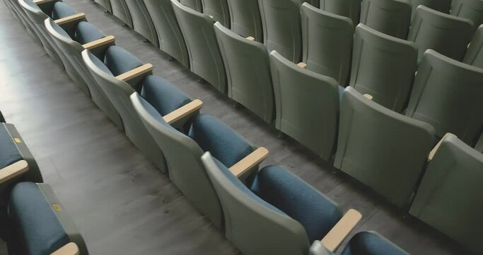 Overhead video of an empty renovated school theater, auditorium blue / gray seats, chairs and new carpet in the aisle and luxury vinyl tile under the seats.