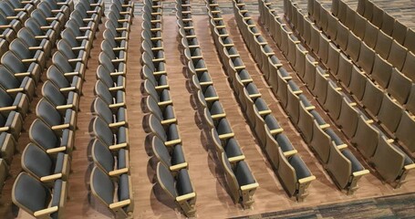 Overhead video of an empty renovated school theater, auditorium blue / gray seats, chairs and new carpet in the aisle and luxury vinyl tile under the seats.