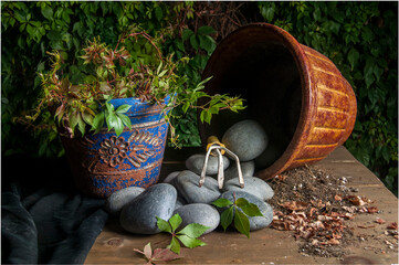 gardening utensils with pots rocks dry leaves on a rustic table with a black background, at night,...
