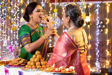 Daughter in law feeds mother in law Laddoo during Diwali celebrations