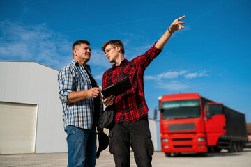 Truck driver talking with transportation manager 