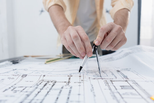 young architect man working using compasses geometric drawing house design plan project. new construction and Interior design ideas. Male professional sketch house building structure on paperwork.