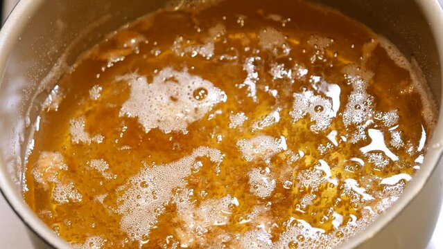 揚げ物を調理中の食用油。揚げカスを取り除いて掃除してる動画。