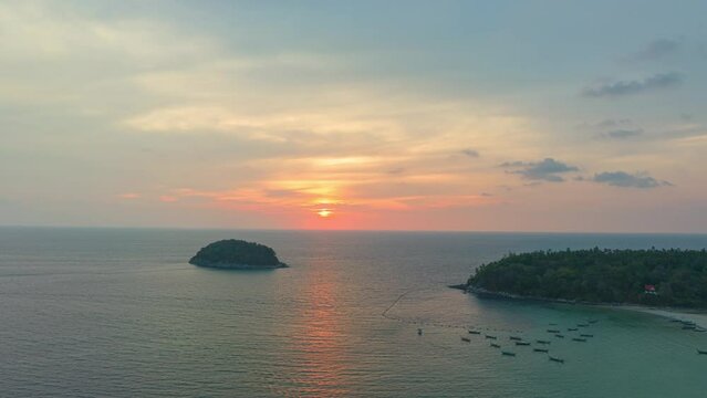 .aerial hyperlapse view scenery sweet sky in sunset above the island. .the sun going down to the sea beside Pu island at Kata beach Phuket Thailand..4k stock footage video in travel concept.