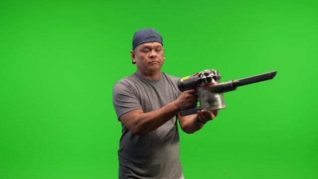 Asian man with vacuum in hand on green screen