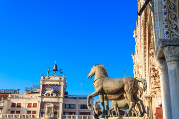 Horses of Saint Mark, also known as the Triumphal Quadriga or Horses of the Hippodrome of Constantinople, and Clock Tower at San Marco Square in Venice, Italy