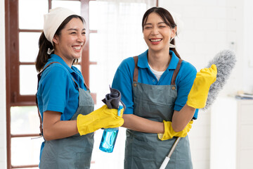 Portrait two Asia woman in workwear maid cleaning home and holding dusting brush and microfiber...