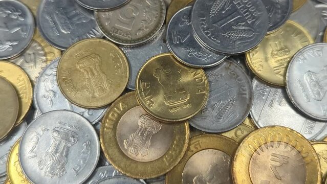 closeup of a pile of one, two, five and ten rupee coins of india made of gold and silver colored metals