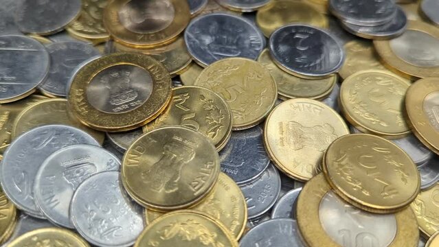 closeup of a pile of one, two, five and ten rupee coins of india made of gold and silver colored metals