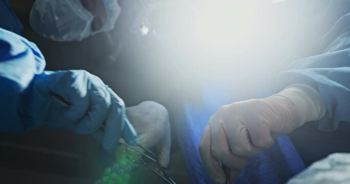 Surgery, hospital and doctors with scalpel for operation, medical emergency and service in theater. Healthcare, teamwork and hands of people with tools for patient injury, wellness and accident