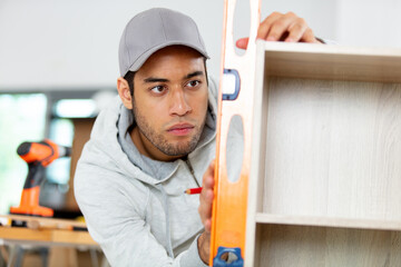 handsome guy building book shelf handmade