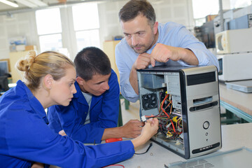 Students looking at cables inside computer
