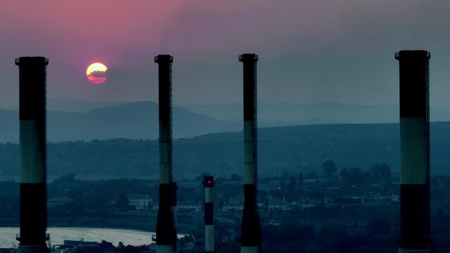 Aerial view of the thermal power plant at sunset. Smog and CO2 air pollution from electricity production waste. High quality 4k footage