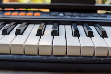 Close-up of piano keys. Piano black and white keys and Piano keyboard musical instrument placed at the home balcony during sunny day.