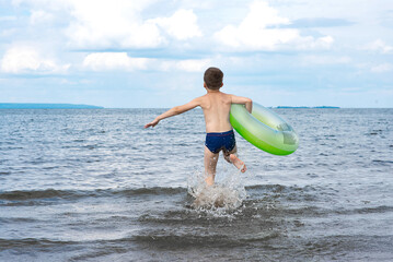 boy runs into water, splashes fly. summer holidays