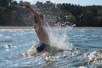 happy boy jumping in the waves, splashing in the water, splashing