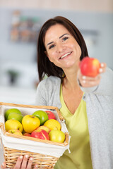 young woman eating fresh red apple inside house kitchen