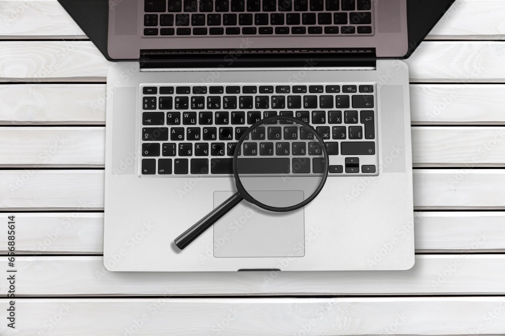 Poster the magnifying glass and computer keyboard on desk