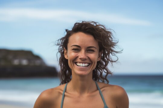 Portrait of smiling young woman standing on beach at the day time