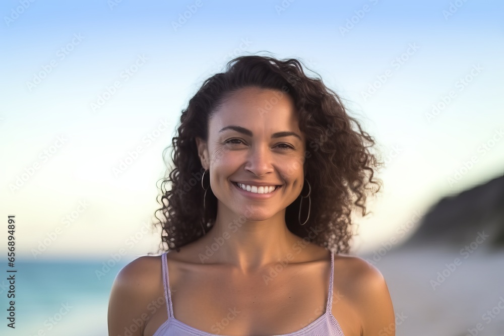 Wall mural portrait of smiling young woman standing on beach at the day time