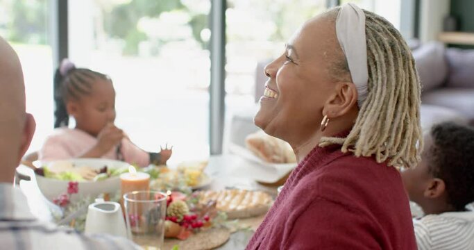 Portrait of african american grandmother with family at thanksgiving dinner table , slow motion - Powered by Adobe