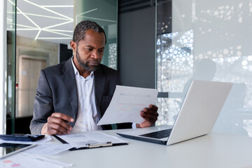 Serious senior experienced financier checking reports, african american businessman in business...