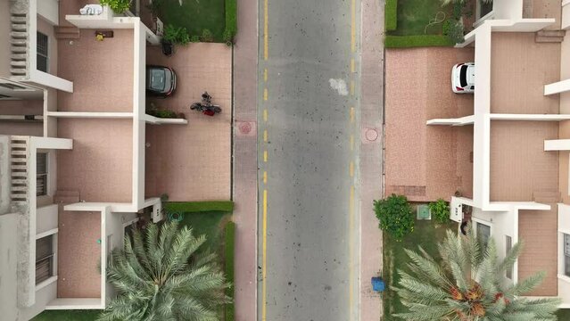 A street view and roofs of the houses from the top as car passes by the houses - lifestyle in Pakistan